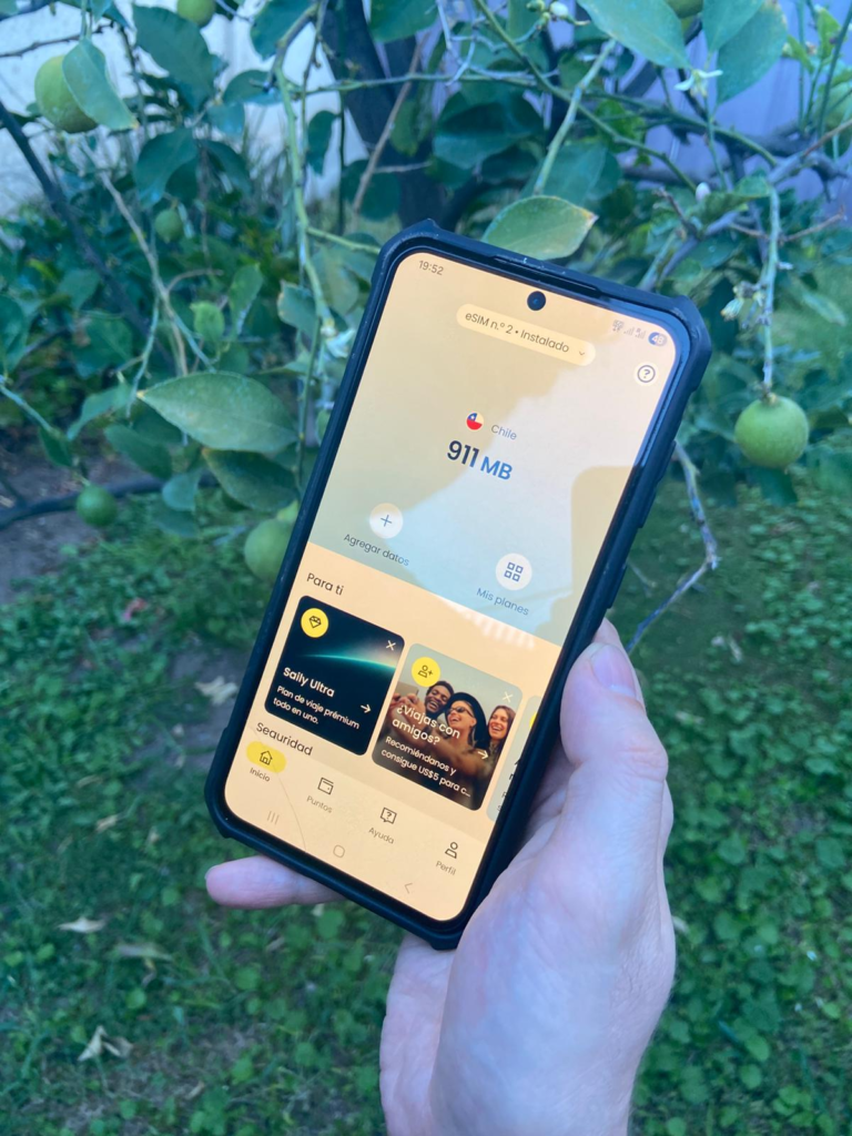Fotografía sosteniendo un teléfono con el plan comprado de la eSIM Saily para ponerla a prueba en un entorno rural chileno