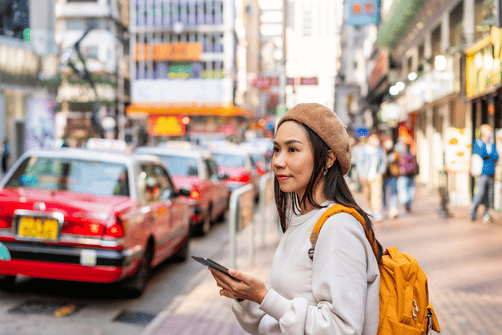 Voyageuse avec smartphone en Chine – meilleurs fournisseurs eSIM 2025