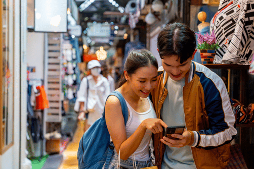 Voyageuse avec smartphone en Thaïlande – meilleurs fournisseurs eSIM 2025